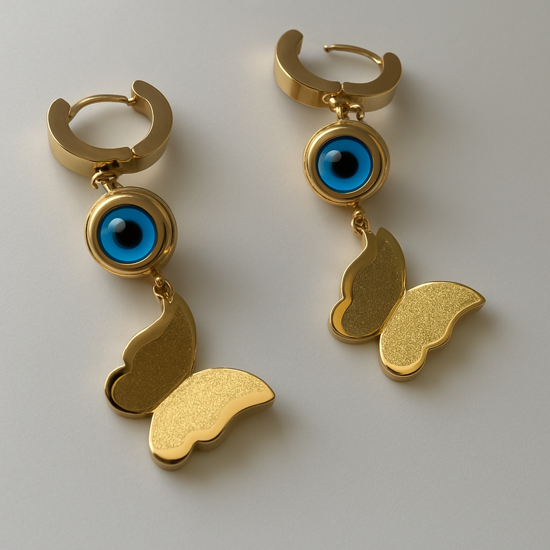 Gold tone earrings with blue eye design on a light gray background