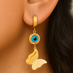 Gold tone earring with blue gemstone worn on an ear