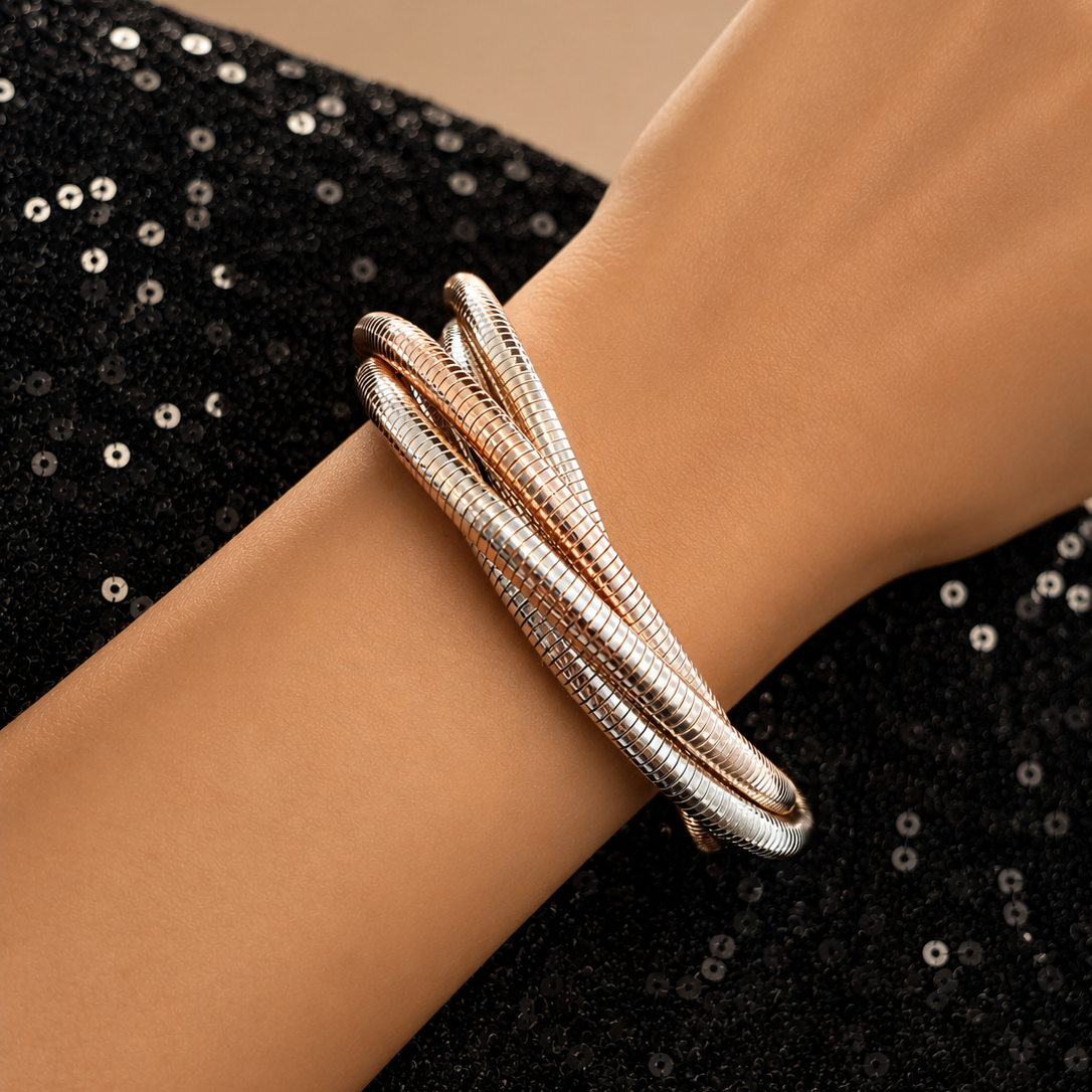 Rose gold bracelet on a wrist with a black sequin background