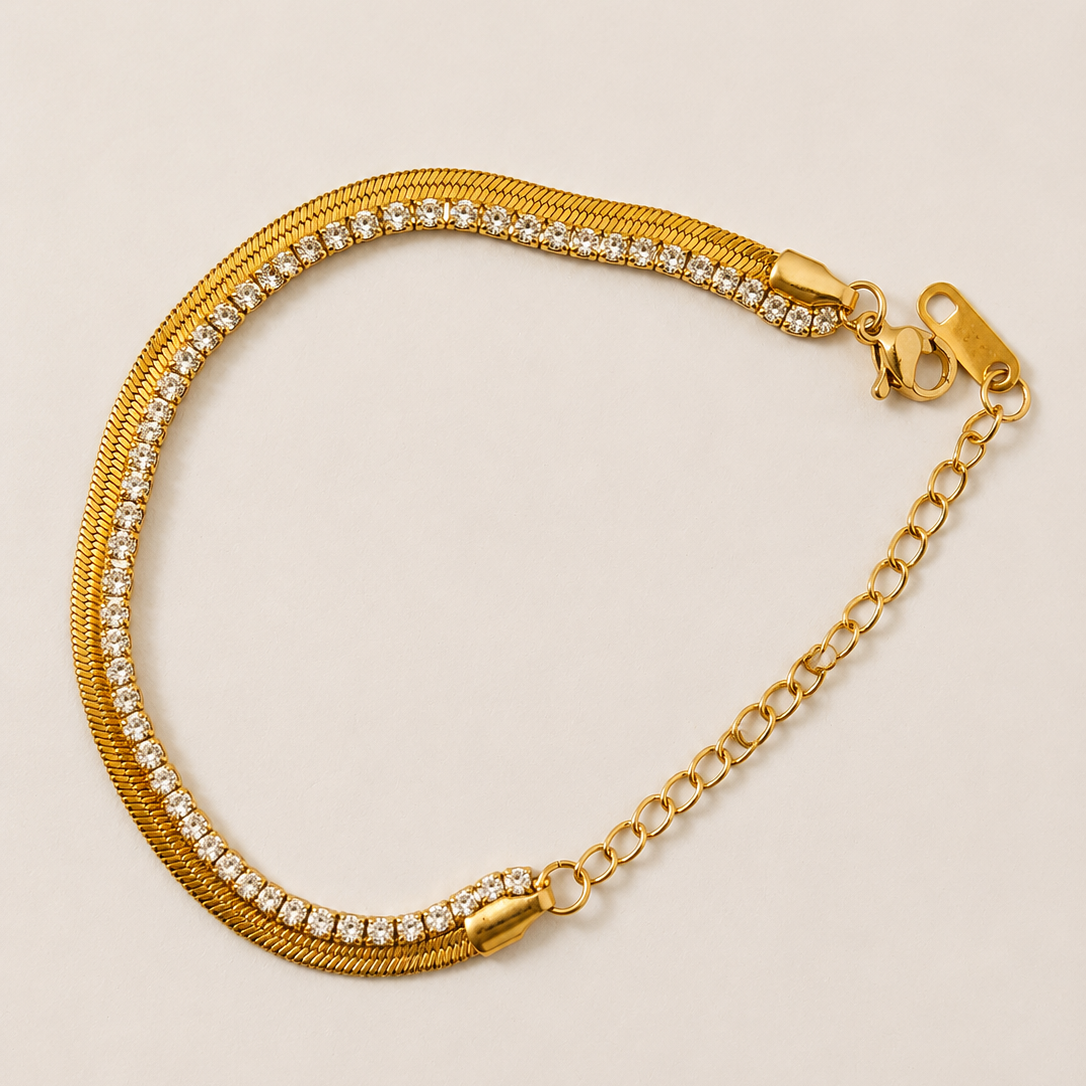 Gold tone bracelet with clear stones on a beige background