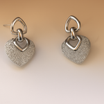 Pair of silver heart-shaped earrings on a beige background