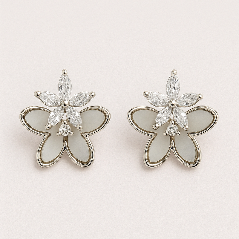 Butterfly-shaped earrings with gemstones on a light pink background