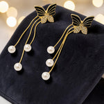Butterfly hairpins with pearl details on a dark surface with a bokeh light background