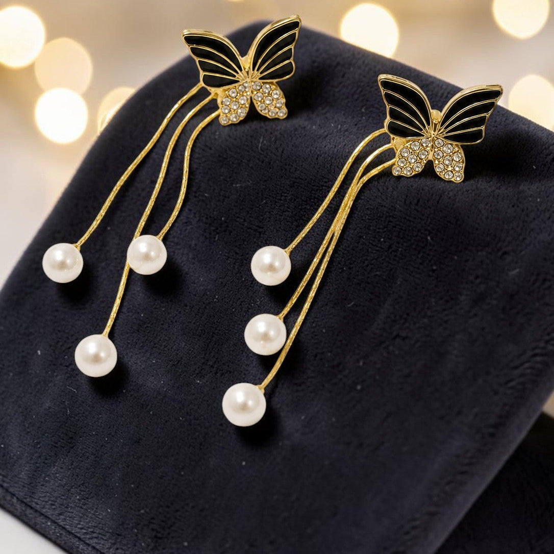 Butterfly hairpins with pearl details on a dark surface with a bokeh light background