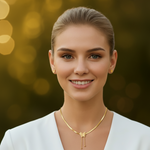 Woman wearing a gold tone necklace with a blurred golden background