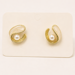 Gold tone earrings with pearl centers on a white card
