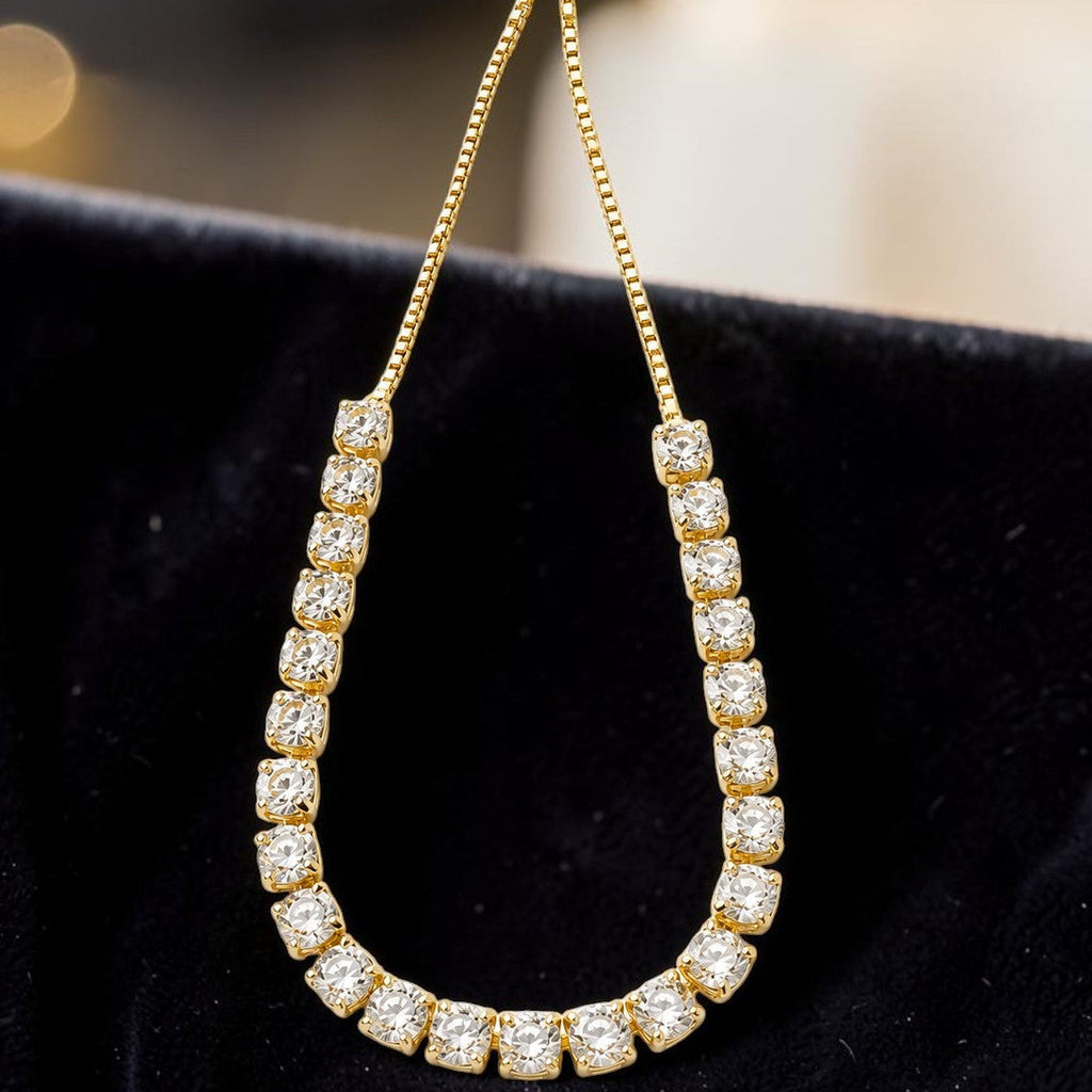 Gold tone bracelet with diamond accents on a black background