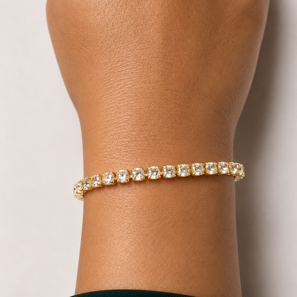 Gold tone bracelet with clear stones on a wrist against a light background