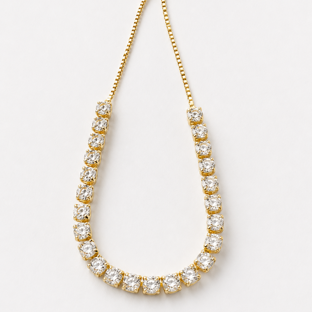 Gold tone bracelet with clear stones on a white background
