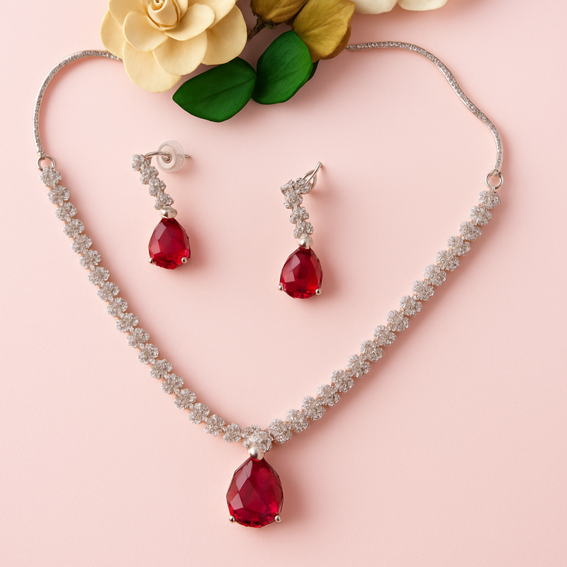 Jewelry set with red gemstones on a pink background