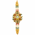 A traditional Indian gold-plated wrist watch (chotki) decorated with red and green stones, white pearl beads, and gold-toned metal links, shown against a plain white background.