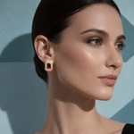 Woman wearing a pair of earrings against a light blue background