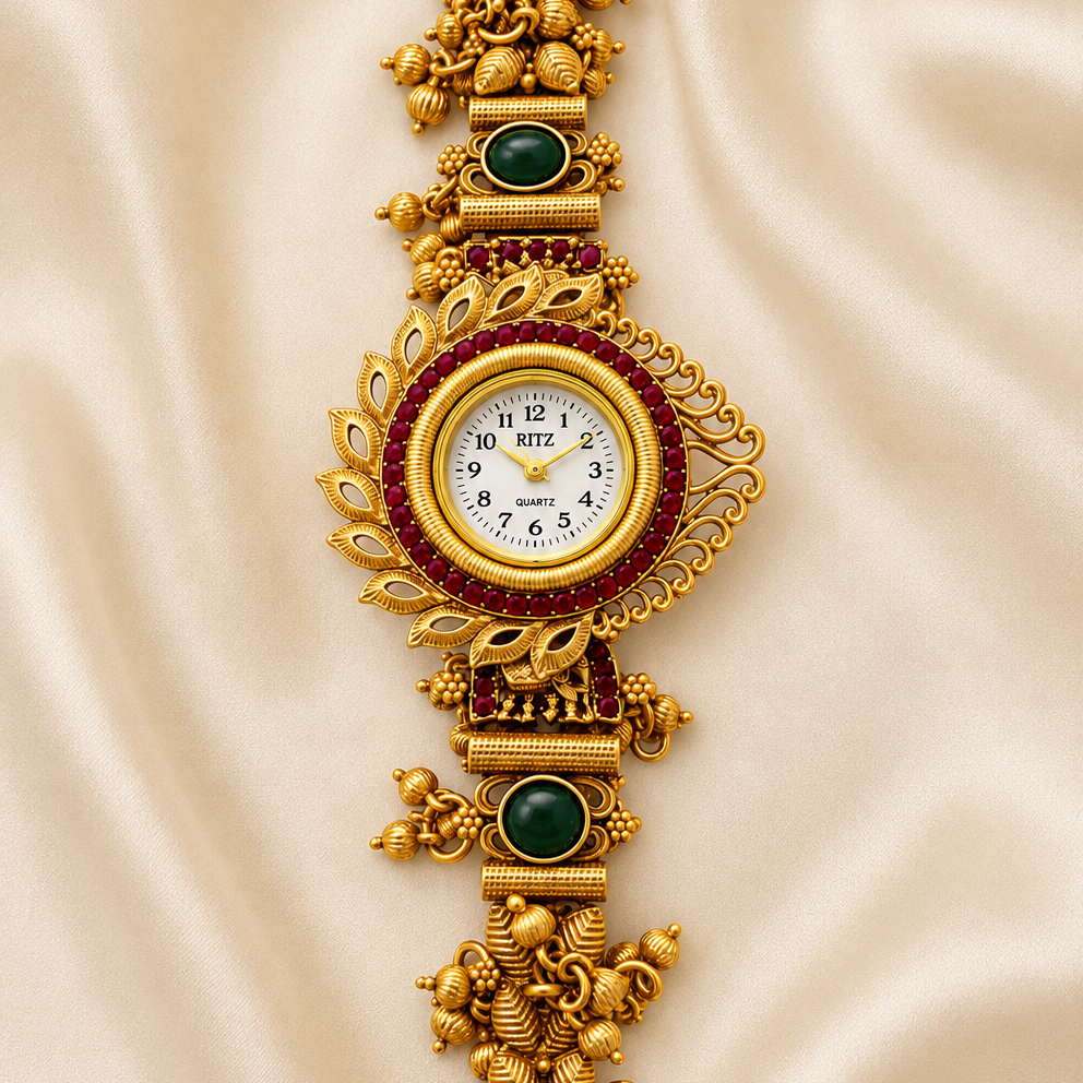An ornate gold-toned jewelry watch with intricate filigree details, green stone accents, and a white dial, displayed on a draped beige satin fabric background.