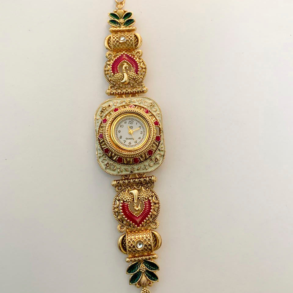 An ornate gold-plated watch bracelet featuring red and green enamel details, a central round watch face, and decorative motifs on a plain white background.