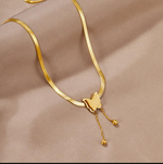 Gold necklace with a butterfly pendant on a beige fabric background