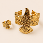 Gold tone eagle-shaped cufflinks on a beige background