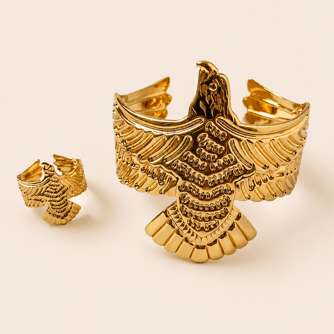 Gold tone eagle-shaped cufflinks on a beige background