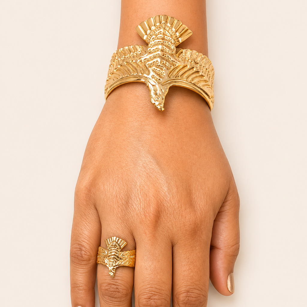 Golden bracelet and ring on a hand against a white background