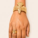 Golden bracelet and ring on a hand against a white background