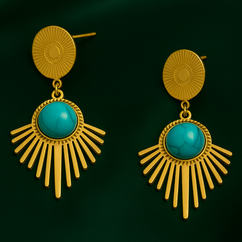 Gold earrings with turquoise stones on a dark green background