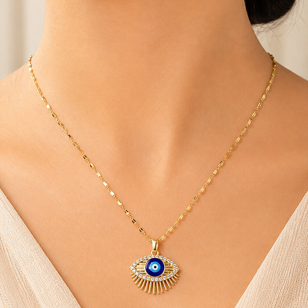 Gold tone necklace with an eye-shaped pendant worn by a model