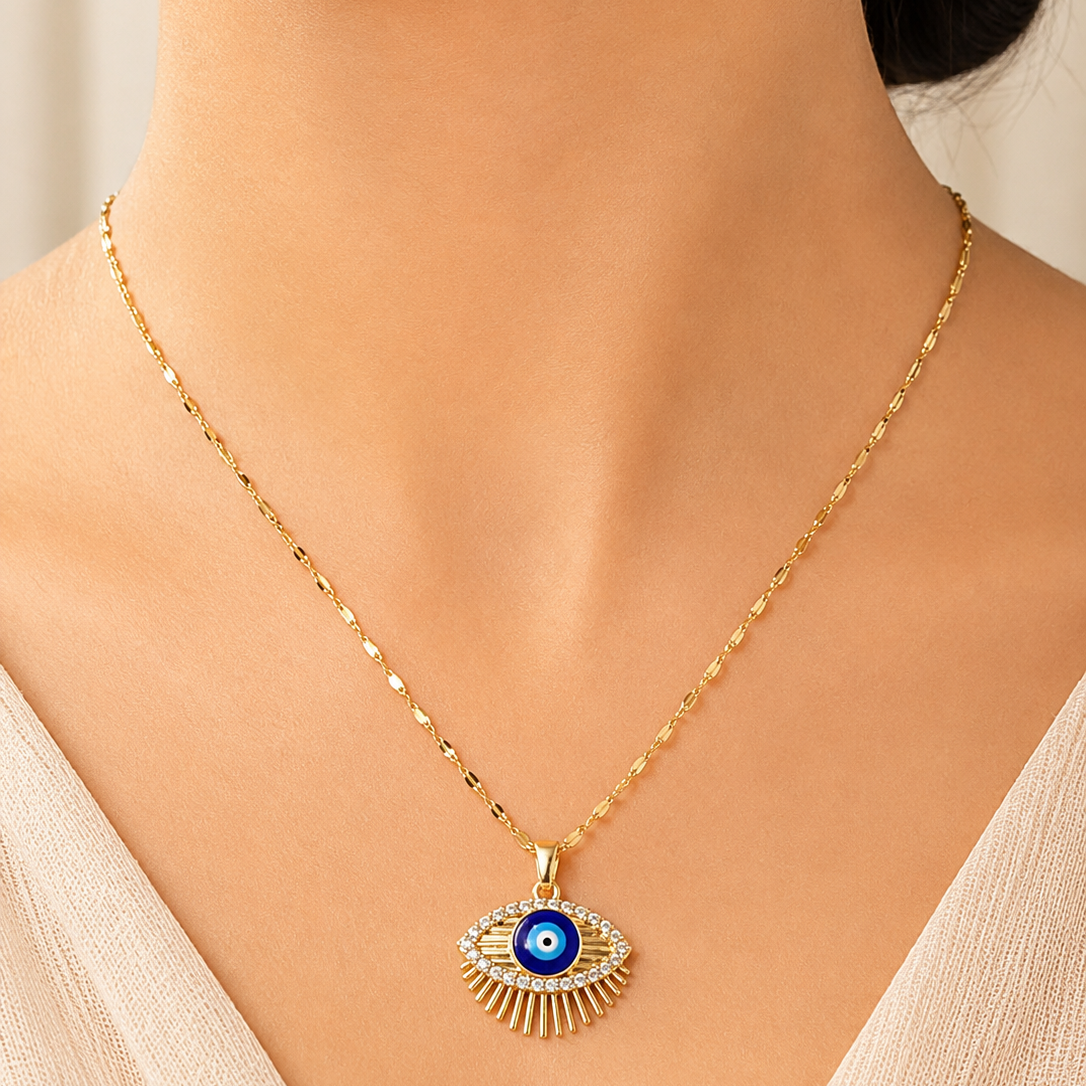 Gold tone necklace with an eye-shaped pendant worn by a model