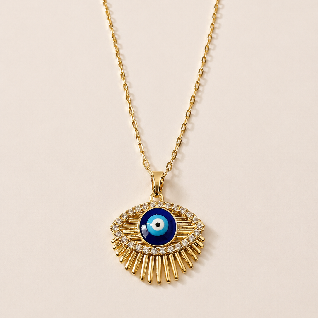 Gold tone necklace with an eye-shaped pendant on a beige background